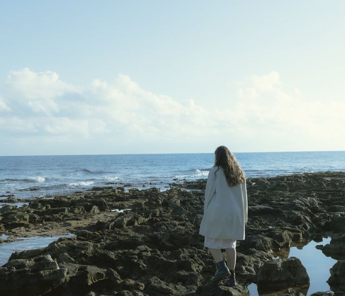 Serene person meditating in a calm, minimalist environment.